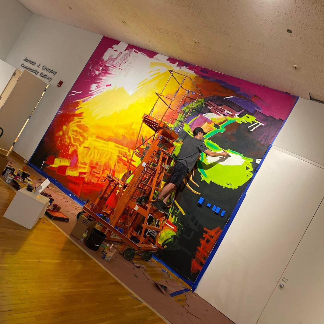 Professional muralist painting large-scale abstract mural The Cosmonaut using a scissor lift inside the Jerome J. Crowley Community Gallery at the South Bend Museum of Art by VanGalder Murals