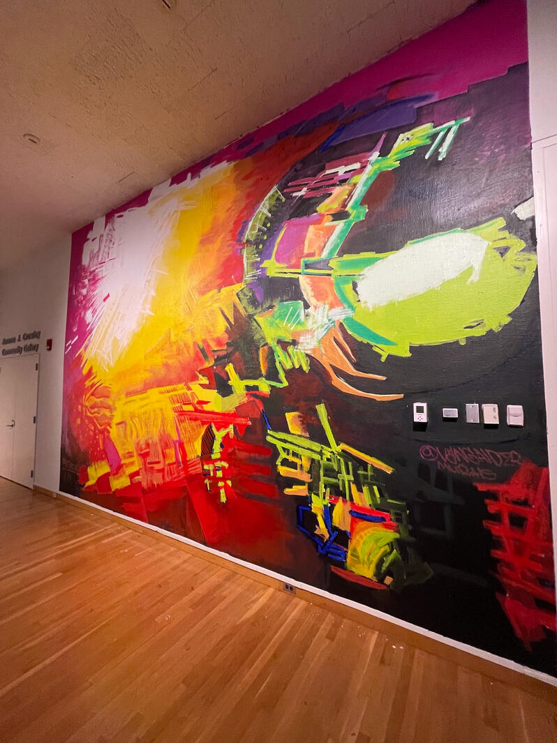 Perspective view down an interior corridor featuring a large-scale vibrant abstract fine art mural at the South Bend Museum of Art by VanGalder Murals