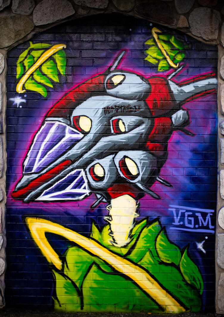 Custom hand-painted exterior brick wall mural featuring a sci-fi hop harvesting spaceship for Hop Station craft beer bar and brewery by VanGalder Murals