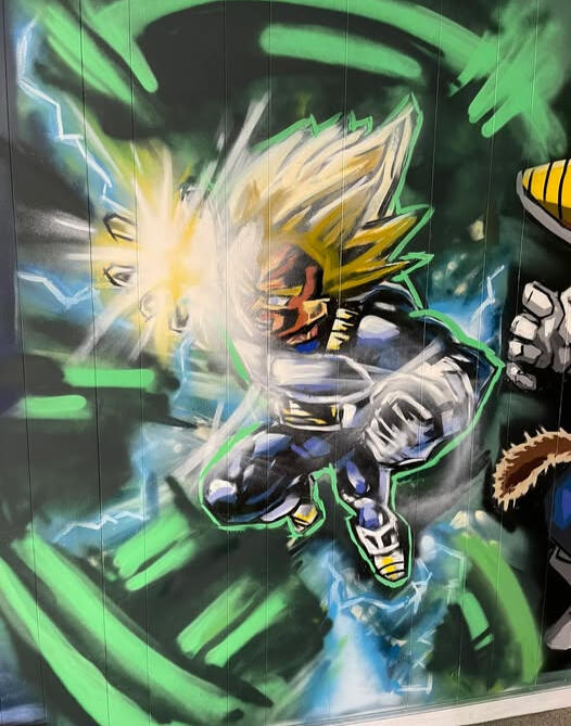 Custom hand-painted residential interior mural featuring a dynamic action shot of Super Saiyan Vegeta from Dragon Ball Z firing a glowing energy blast, executed for a private man cave and gaming room by VanGalder Murals